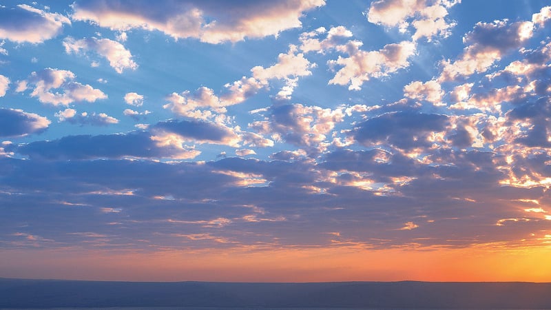 Clouds lit orange at sunset over the Sea of Galilee