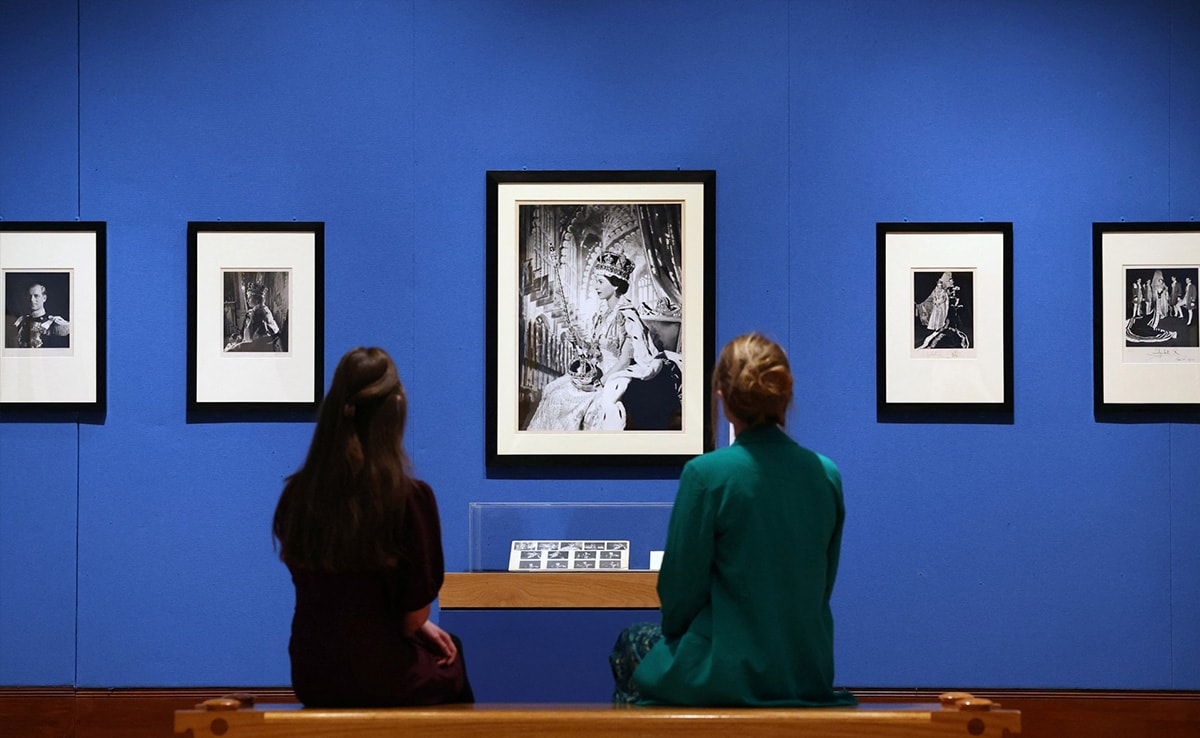 Employees from Royal Collection Trust, Catriona and Meredith pose as they view ‘Coronation Portrait of Queen Elizabeth II' by Cecil Beaton in 1953.