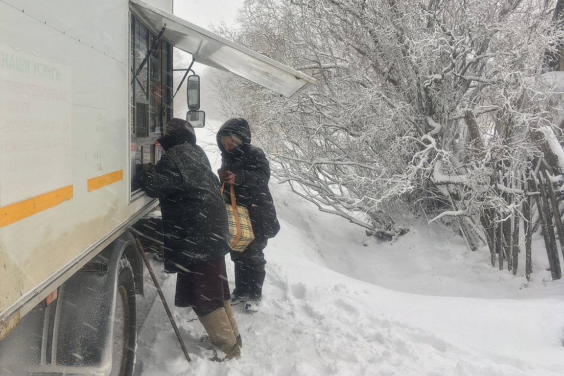 Деревенские жители покупаеют продукты в автолавке во время сильной метели. Фото Сергея Серебро