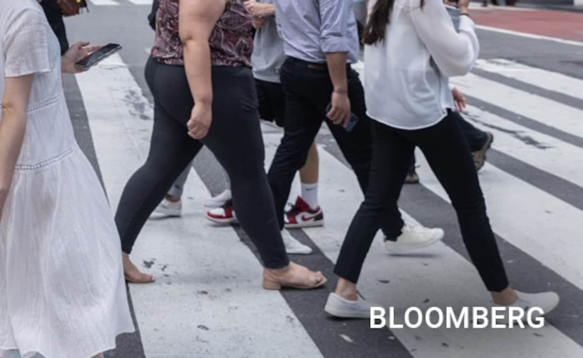 Pedestrians hold umbrellas for protection from the sun during a heat wave in New York, July 27, 2023.