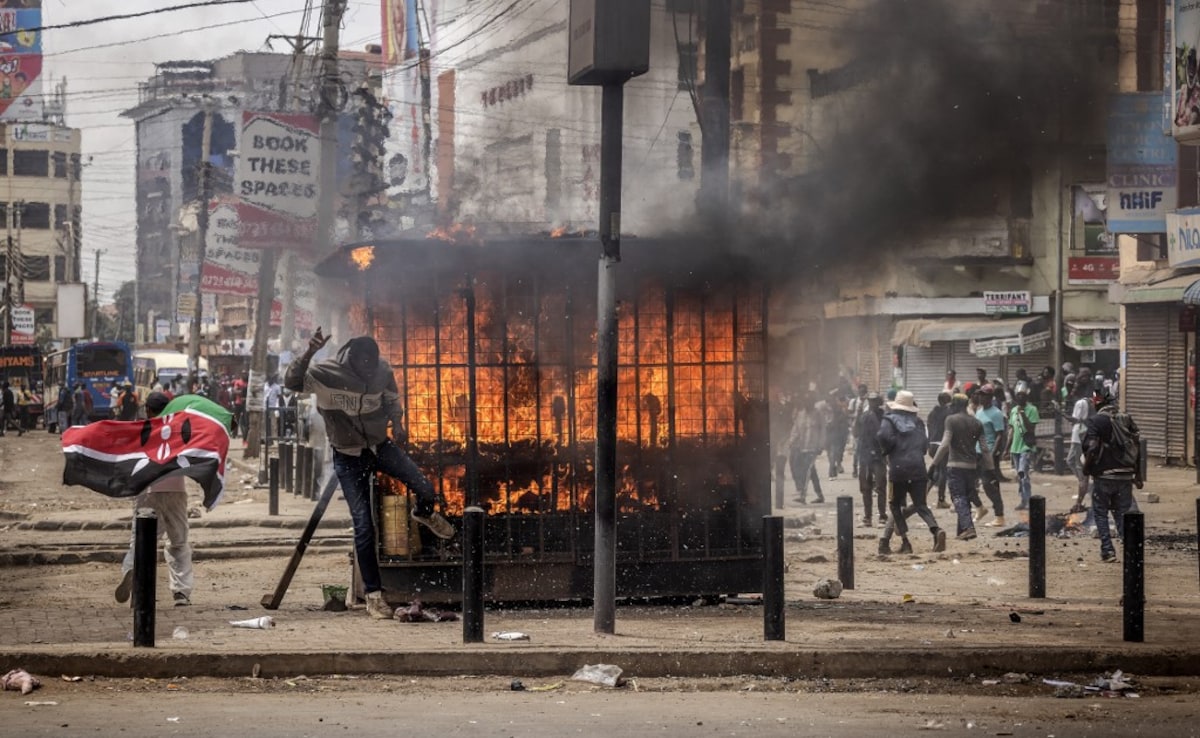 Protesters react after setting urban furniture on fire during an anti-government demonstration