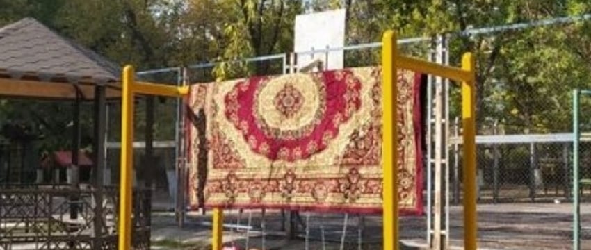 Выбивание ковров во дворе многоэтажки