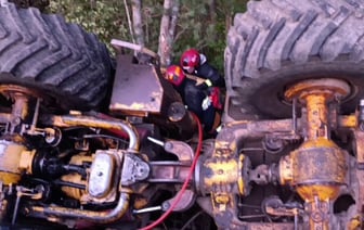 Спасатели достали водителя из перевернувшегося трактора