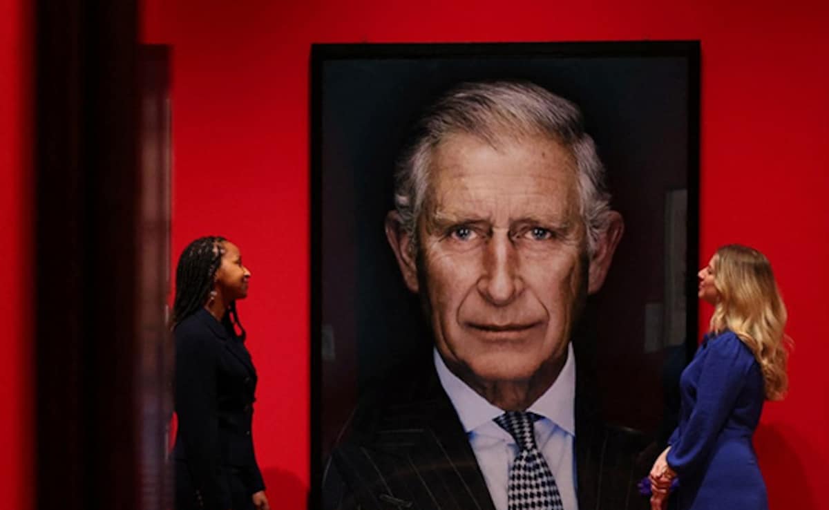 Royal Collection Trust employees pose as they view ‘King Charles III when the Prince of Wales' by Nadav Kander in 2013