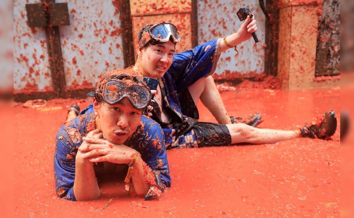Participants pose, while in tomato pulp, during the annual food fight festival La Tomatina in Bunol