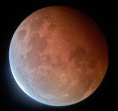 The moon cast in a partial red shadow with a bright edge on the opposite side.