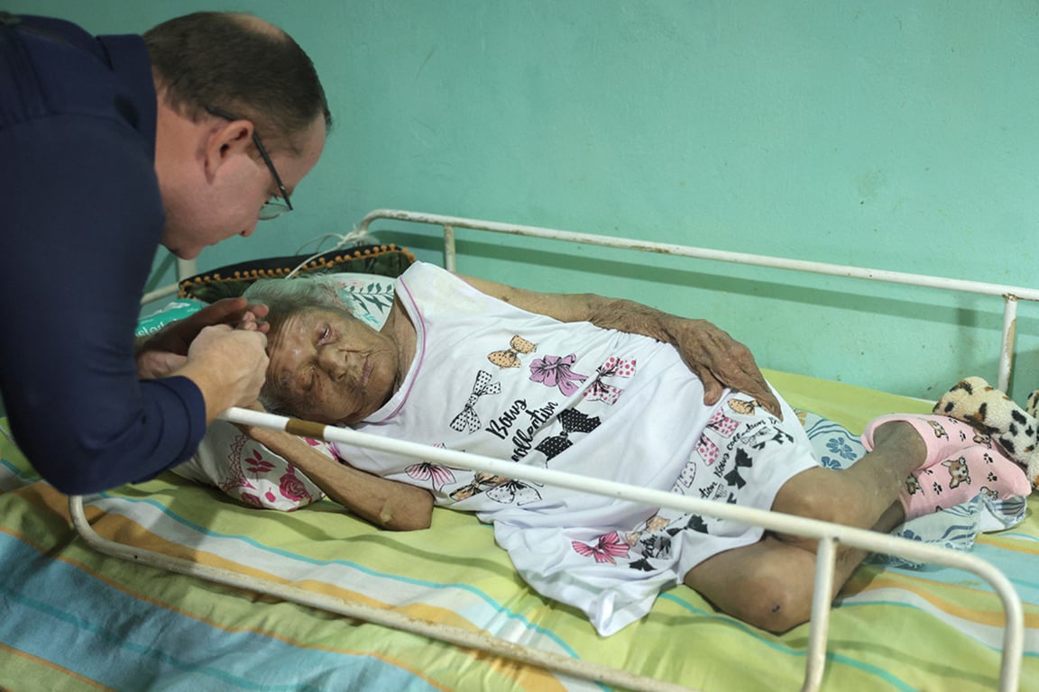 Врач-гериатр Жуаир ди Абреу Перейра разговаривает с 119-летней Деолирой Глисерией Педру да Силва в ее доме в Итаперуне, штат Рио-де-Жанейро, Бразилия, 14 января 2025 года. Фото: Reuters