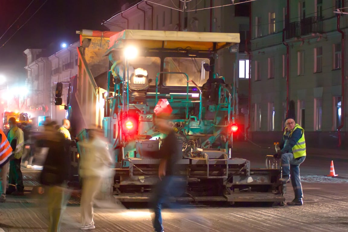 Пешеходы рядом с асфальтоукладчиком. Ночные работы по замене асфальтобетонного покрытия на улице Ленина в Витебске. Фото Сергея Серебро