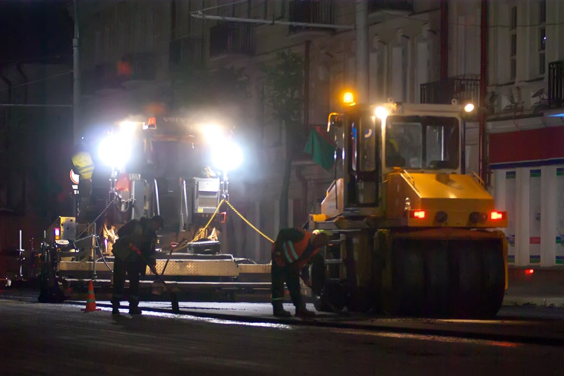 Следом за асфальтоукладчиком идет каток. Ночные работы по замене асфальтобетонного покрытия на улице Ленина в Витебске. Фото Сергея Серебро