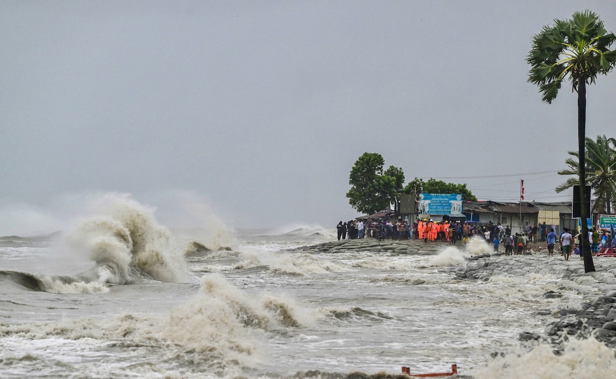 People gather along the sea shore amid rainfall in Kuakata.