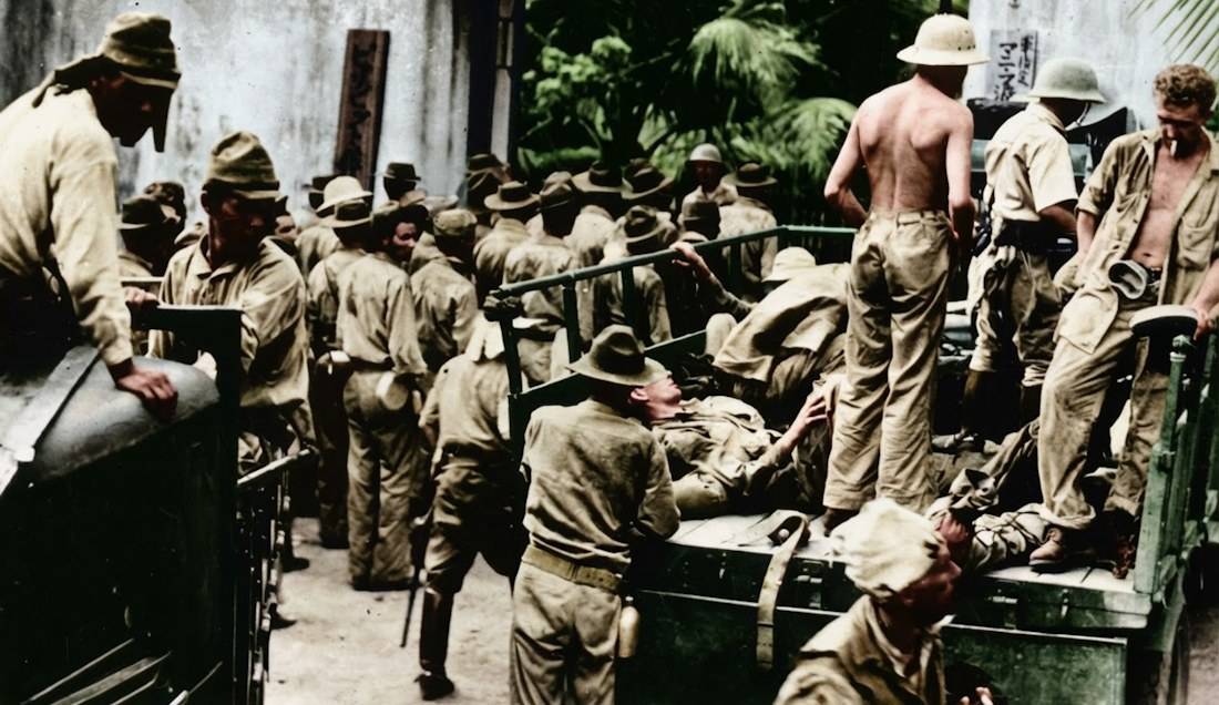 Prisonniers de guerre américains et philippins capturés par l'armée japonaise à Corregidor en 1942, rassemblés près de camions militaires durant la Seconde Guerre mondiale.