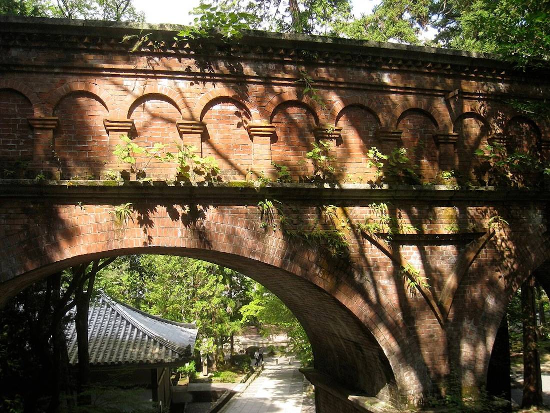 Aqueduc Suirokaku en briques rouges de style occidental au temple Nanzen-ji à Kyoto, ouvrage d'art historique du canal du lac Biwa entouré de végétation.