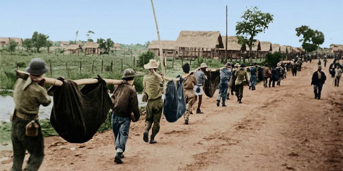 Prisonniers de guerre américains et philippins transportant des camarades malades ou blessés dans des brancards de fortune pendant la marche de la mort de Bataan en 1942.