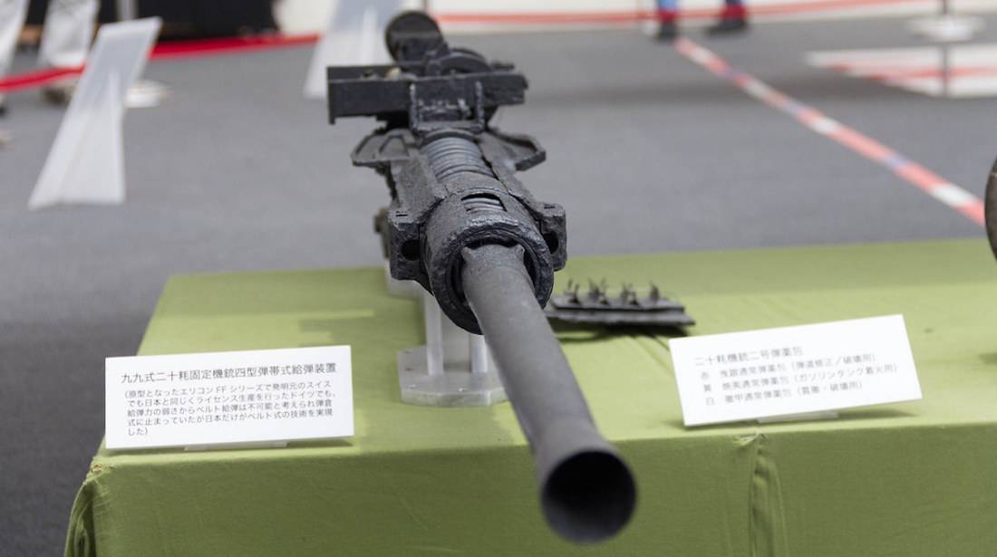 Canon automatique japonais Type 99 exposé sur une table, arme emblématique de l'avion de chasse Mitsubishi A6M Zero de la Seconde Guerre mondiale.