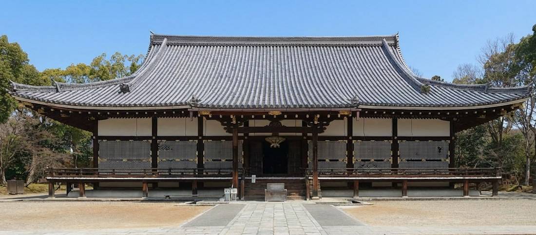 Façade du bâtiment Kondo du temple Ninna-ji à Kyoto, classé au patrimoine mondial de l'UNESCO, montrant son architecture bouddhiste japonaise traditionnelle sous un ciel bleu.