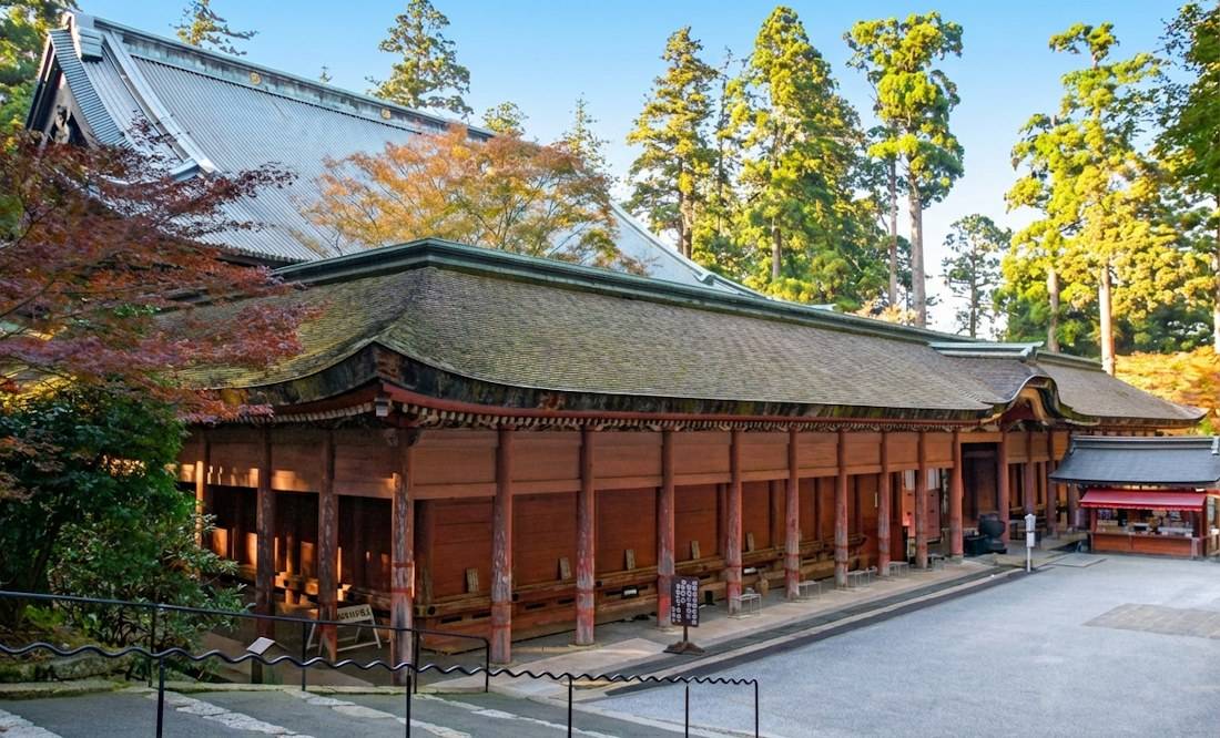 Vue extérieure du Konpon-chūdō, le bâtiment principal du temple Enryaku-ji sur le mont Hiei près de Kyoto, montrant l'architecture bouddhiste traditionnelle japonaise entourée de cèdres et de feuillages d'automne.
