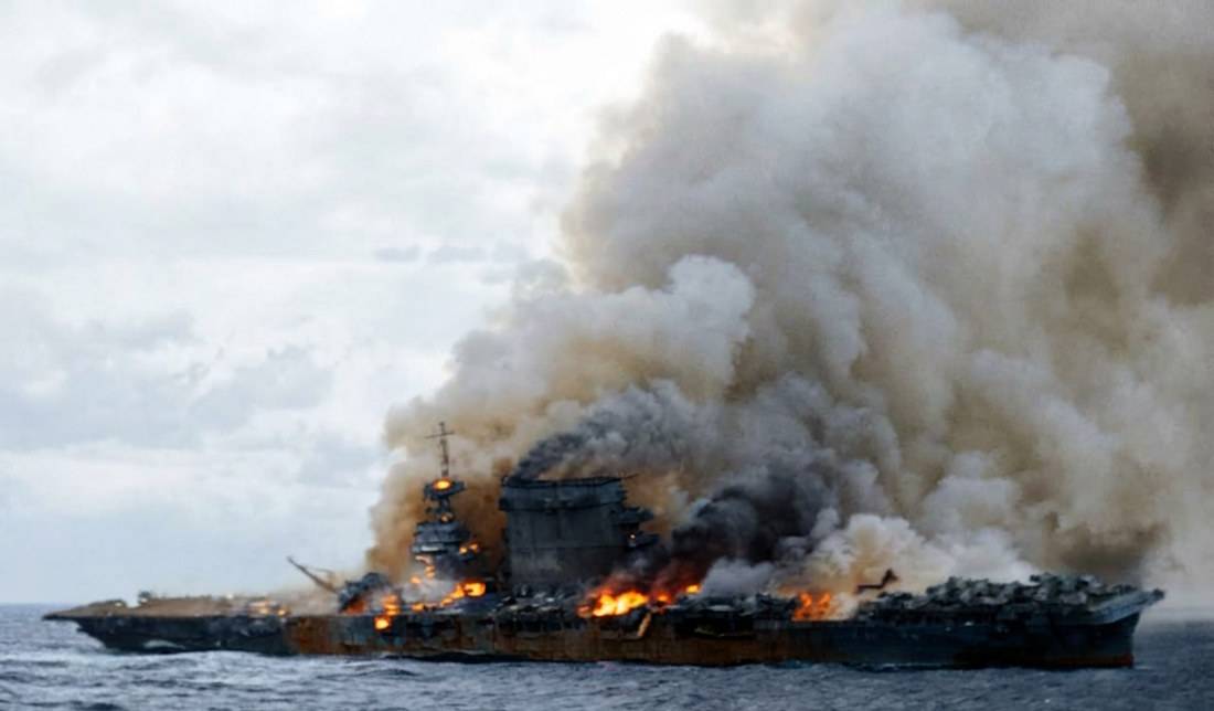 Porte-avions USS Lexington CV-2 en feu et en cours d'évacuation par son équipage lors de la bataille de la mer de Corail en mai 1942 pendant la Seconde Guerre mondiale.