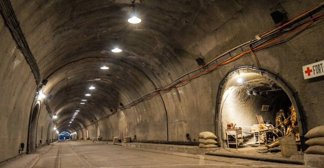 Vue intérieure du tunnel de Malinta sur l'île de Corregidor aux Philippines, montrant la structure voûtée en béton, l'éclairage d'époque et une entrée latérale vers l'ancien hôpital militaire de la Seconde Guerre mondiale.
