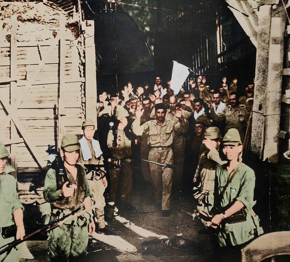 Soldats américains et philippins sortant du tunnel de Malinta les mains levées pour se rendre aux troupes japonaises lors de la chute de Corregidor en mai 1942.