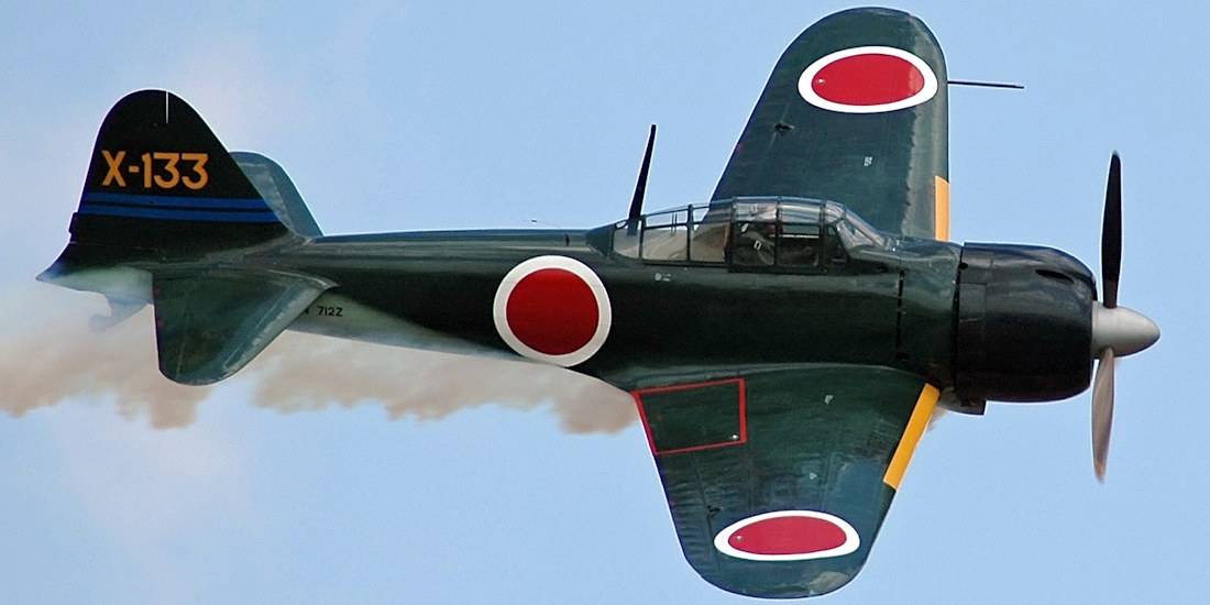 Chasseur japonais Mitsubishi A6M Zero en vol avec cocardes rouges Hinomaru et immatriculation X-133 sur la queue.