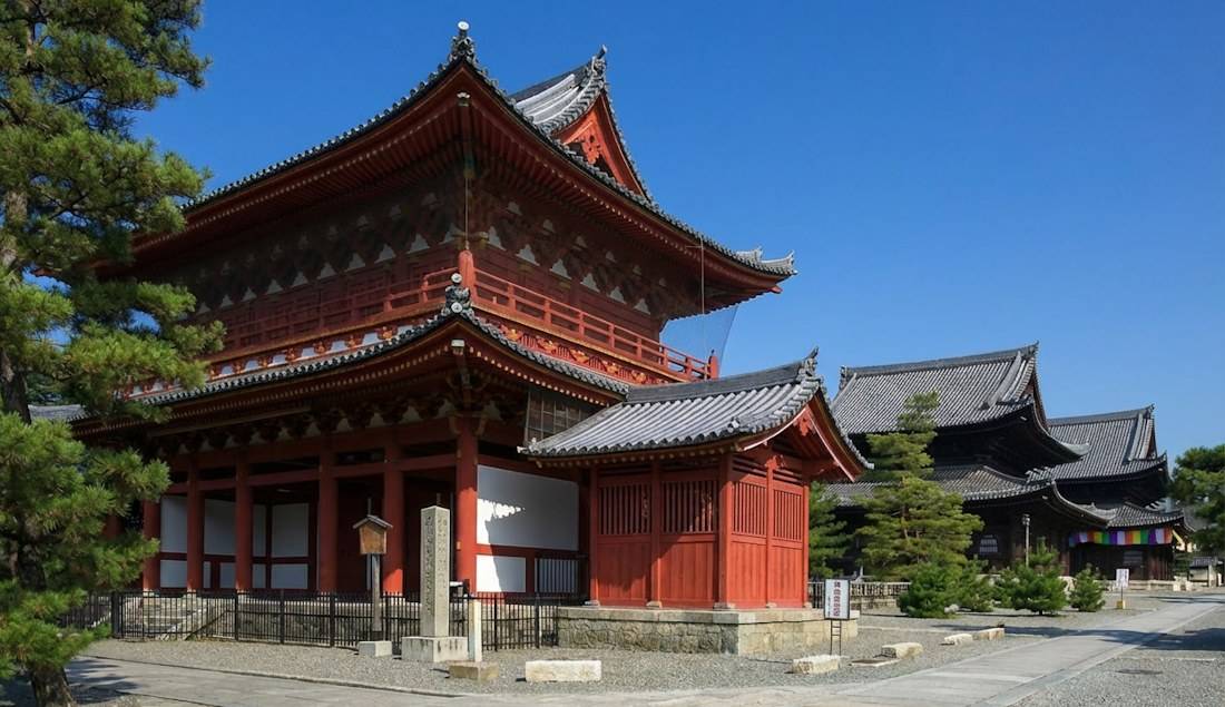 Temple Myōshin-ji à Kyoto au Japon avec son architecture bouddhiste zen traditionnelle en bois rouge sous un ciel bleu clair.