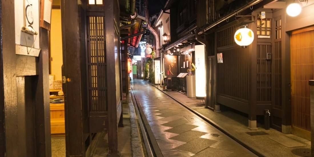 Ruelle étroite de Ponto-cho à Kyoto la nuit avec des lanternes traditionnelles japonaises éclairées devant des restaurants en bois.