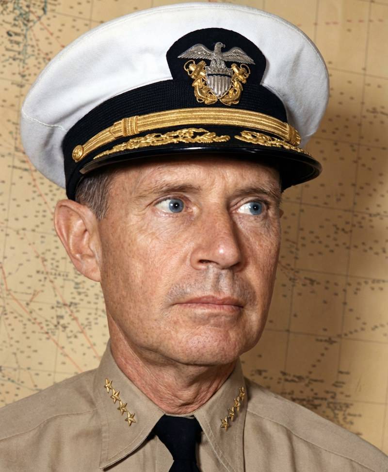 Portrait en gros plan de l'amiral Raymond A. Spruance en uniforme de la marine américaine avec quatre étoiles sur le col, posant devant une carte maritime historique.