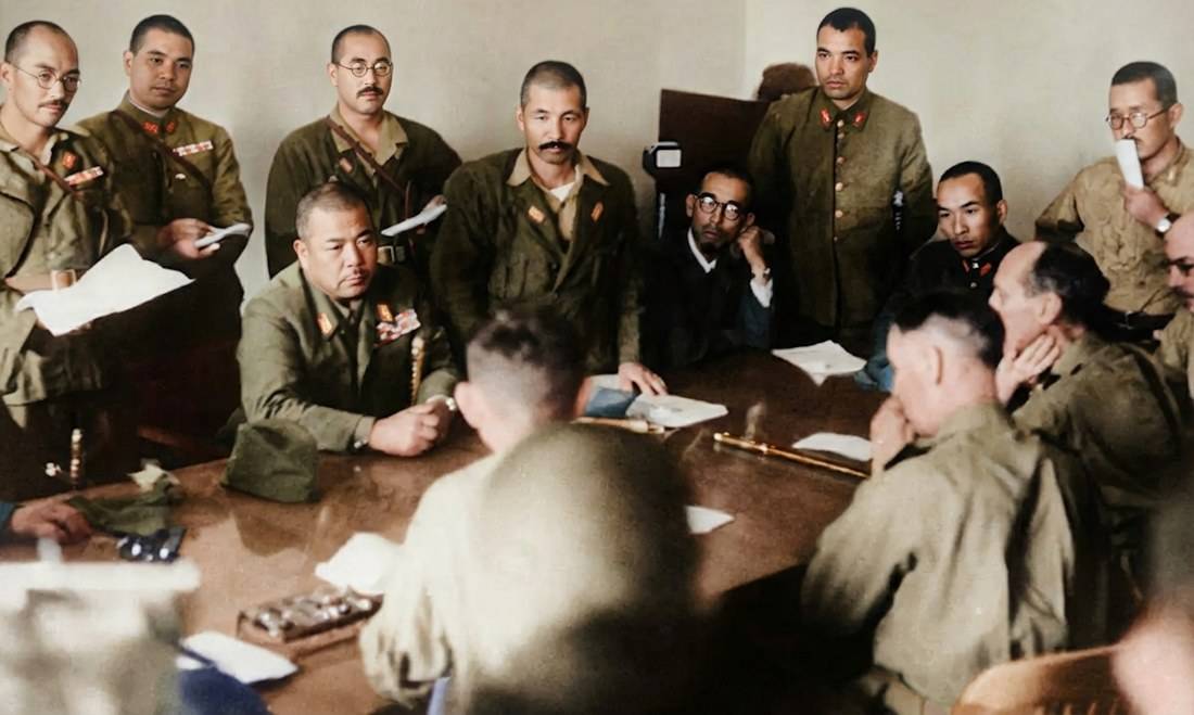 Photographie colorisée de la reddition de Singapour en 1942 montrant le général japonais Tomoyuki Yamashita face au général britannique Arthur Percival lors des négociations à l'usine Ford.