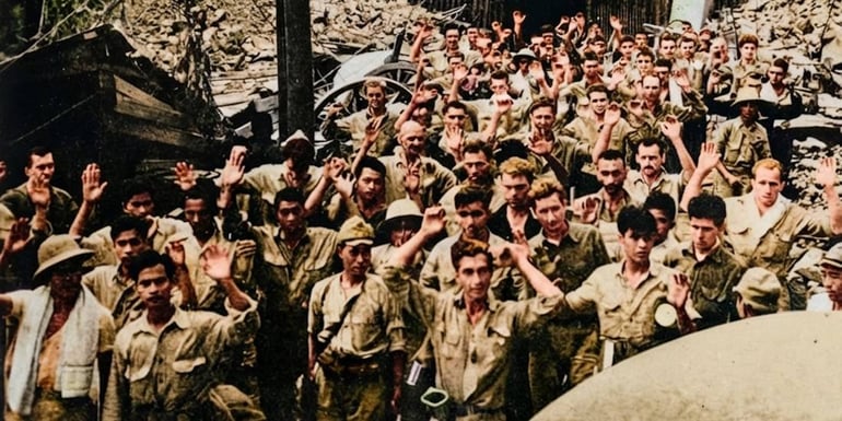 Soldats américains et philippins les mains levées lors de la reddition aux forces japonaises aux Philippines en 1942, illustrant la chute de Corregidor et de Bataan pendant la Seconde Guerre mondiale.