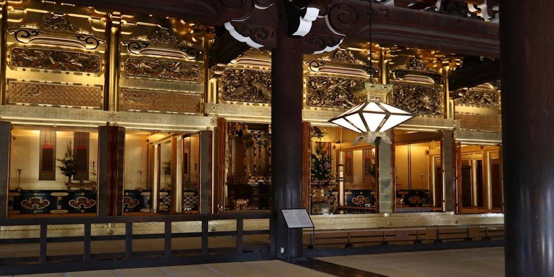 Intérieur doré de l'Amida-do au temple Higashi Hongan-ji à Kyoto, Japon, montrant les détails sculptés, les boiseries sombres et les lanternes traditionnelles.