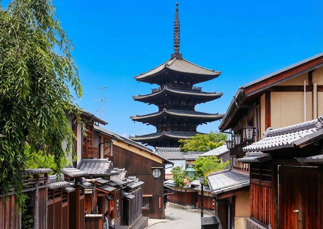 Vue de la pagode Yasaka-no-to dominant les rues traditionnelles du quartier de Gion à Kyoto, Japon, sous un ciel bleu clair.
