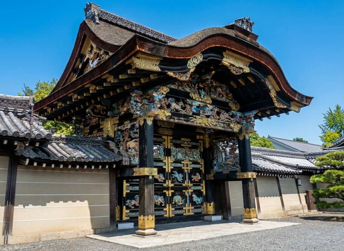 Porte Karamon richement sculptée et dorée du temple Nishi Hongan-ji à Kyoto, Japon, classée au patrimoine mondial de l'UNESCO sous un ciel bleu.
