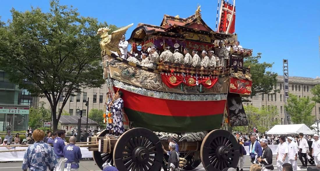 Char de parade Ofune-hoko en forme de bateau lors du festival Gion Matsuri à Kyoto, Japon, avec des participants en costumes traditionnels sous un ciel bleu.