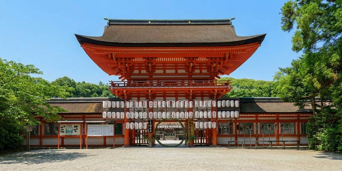 Romon rouge vermillon du sanctuaire Shimogamo-jinja à Kyoto, architecture shinto traditionnelle japonaise sous un ciel bleu.