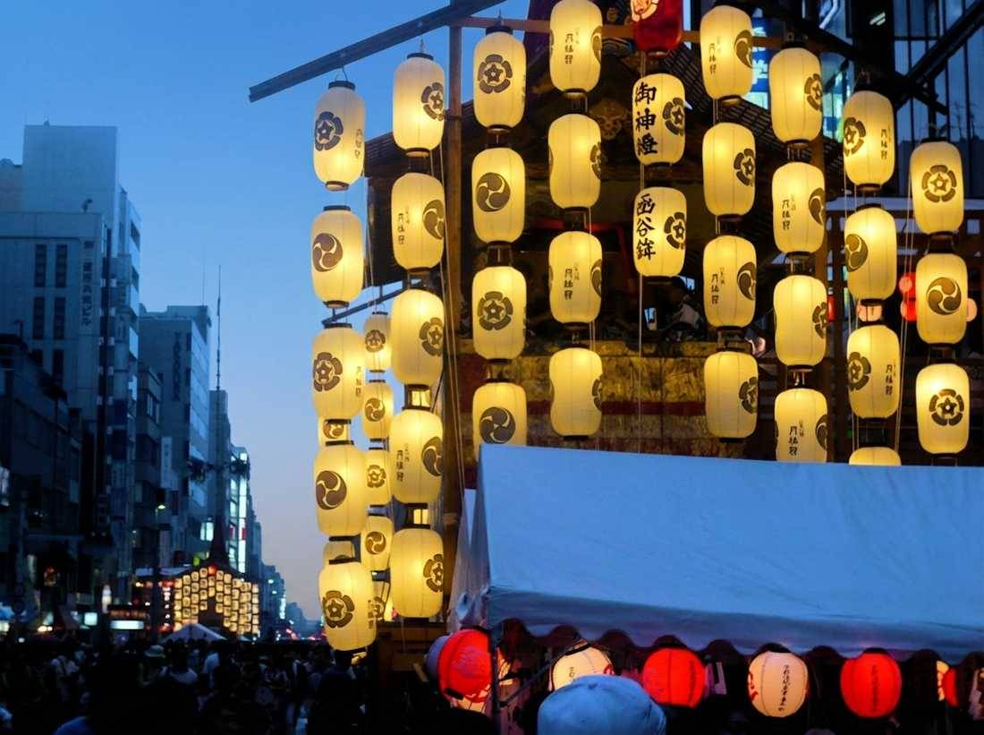 Char de procession Yamaboko illuminé par des lanternes traditionnelles en papier lors du festival Gion Matsuri à Kyoto, Japon, au crépuscule.