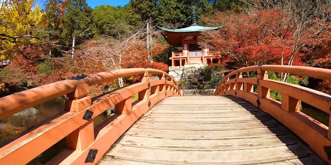 Pont en bois vermillon menant au pavillon Benten-dō entouré d’érables rouges au temple Daigo-ji à Kyoto