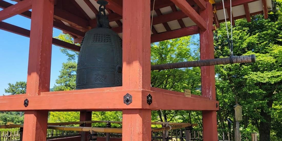 Cloche bonshō du temple Byōdō-in à Kyoto sous un pavillon en bois traditionnel japonais