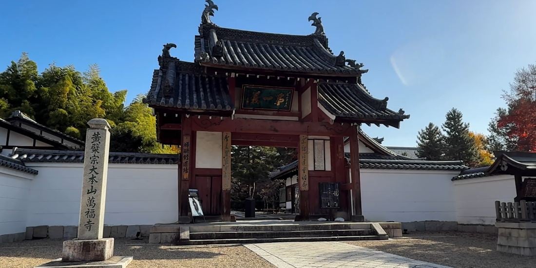Entrée principale en bois du temple bouddhiste zen Manpuku-ji à Uji, Kyoto, avec son architecture de style chinois Ming et une stèle en pierre au premier plan.
