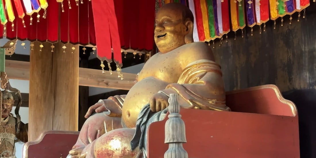 Statue dorée de Hotei souriant dans le Tennō-den du temple Manpuku-ji à Uji au Japon