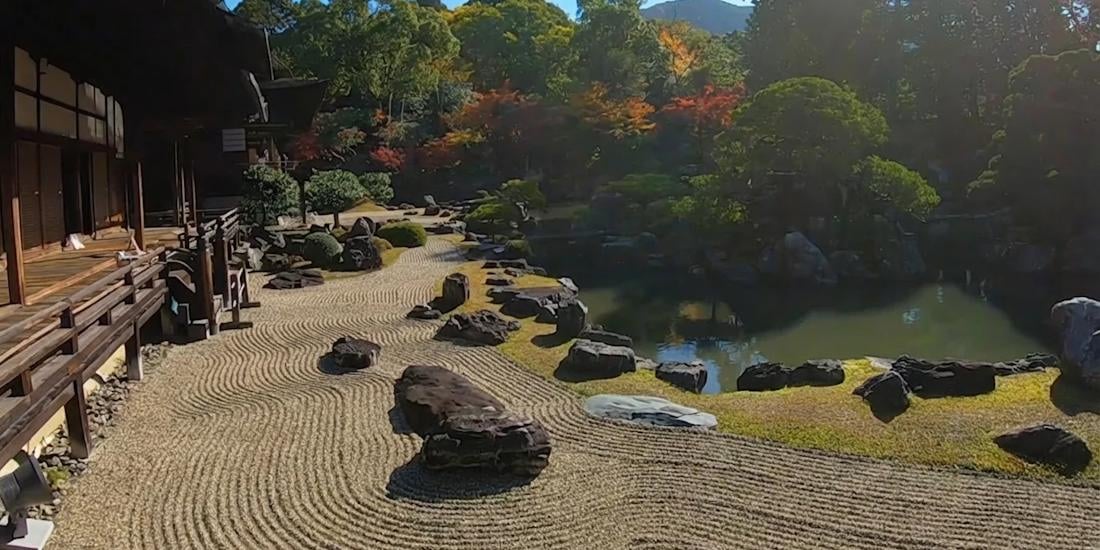 Jardin de pierres zen au temple Daigo-ji à Kyoto avec gravier ratissé, rochers et étang entouré de végétation