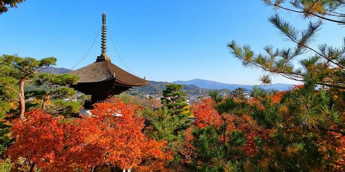Pagode du temple Jojakko-ji à Kyoto entourée d’érables rouges en automne avec vue sur les montagnes