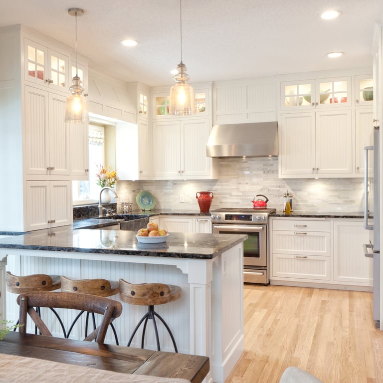 Finished kitchen with custom white cabinetry and stone counters