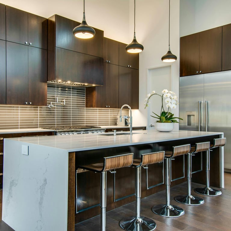 Finished luxury kitchen — dark cabinetry, waterfall marble island
