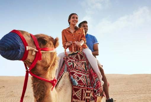 Al Khayma Camp's Morning Desert Safari Includes Adventure Activities, A Camel Ride, And Sandboarding