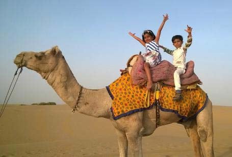 Dubai Camel Riding In The Desert At Sunset With Children