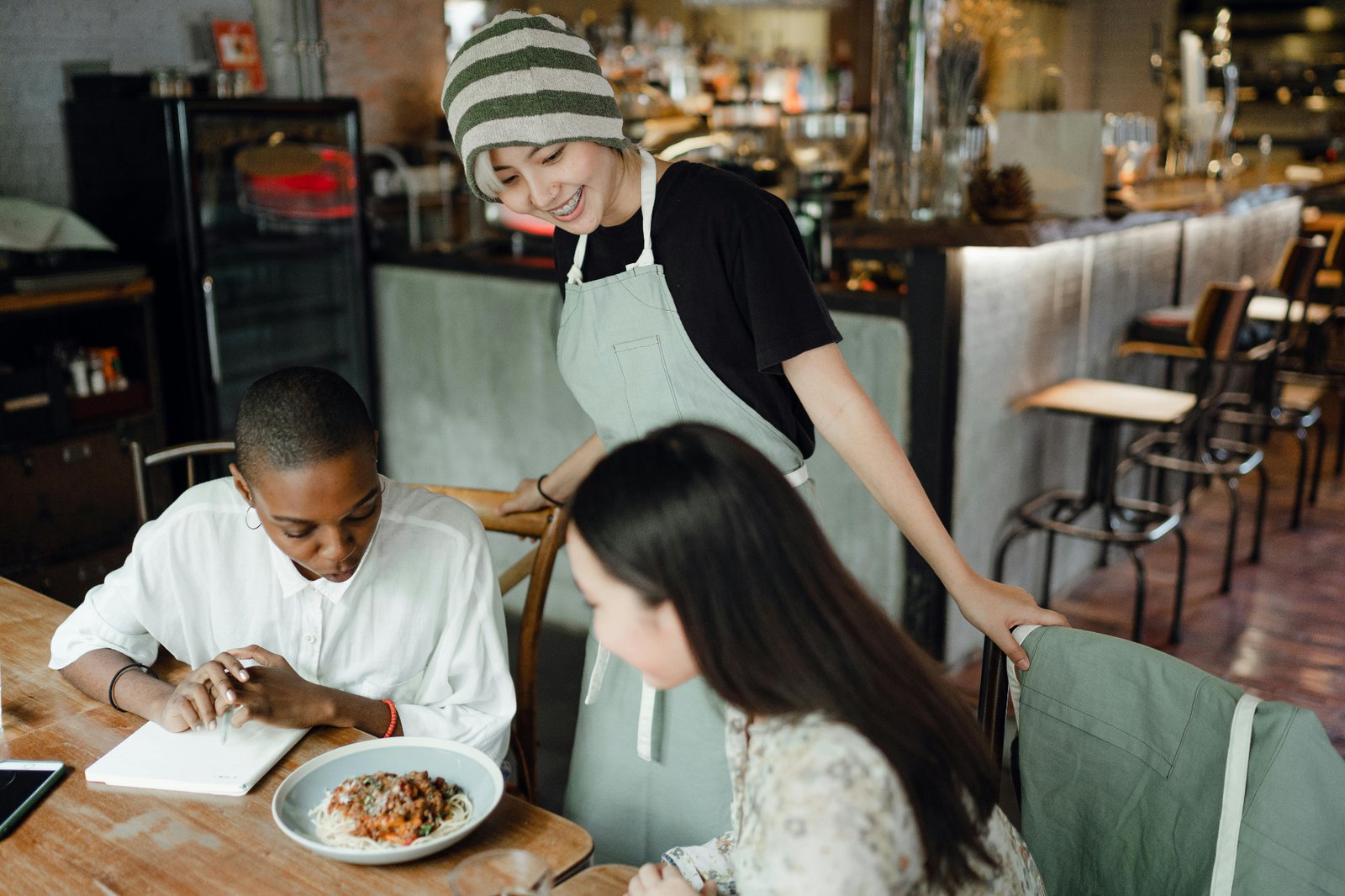 Server attending to guests at a restaurant table without phone interruptions