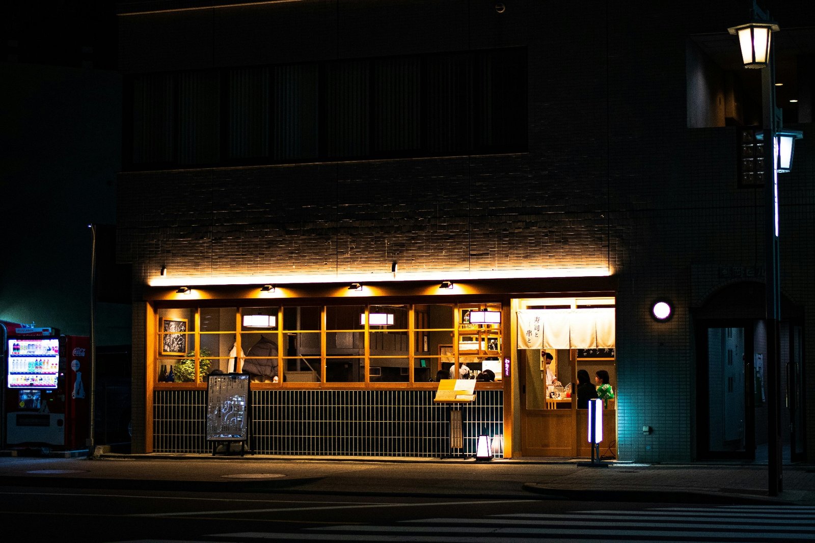 Warmly lit Japanese restaurant storefront at night