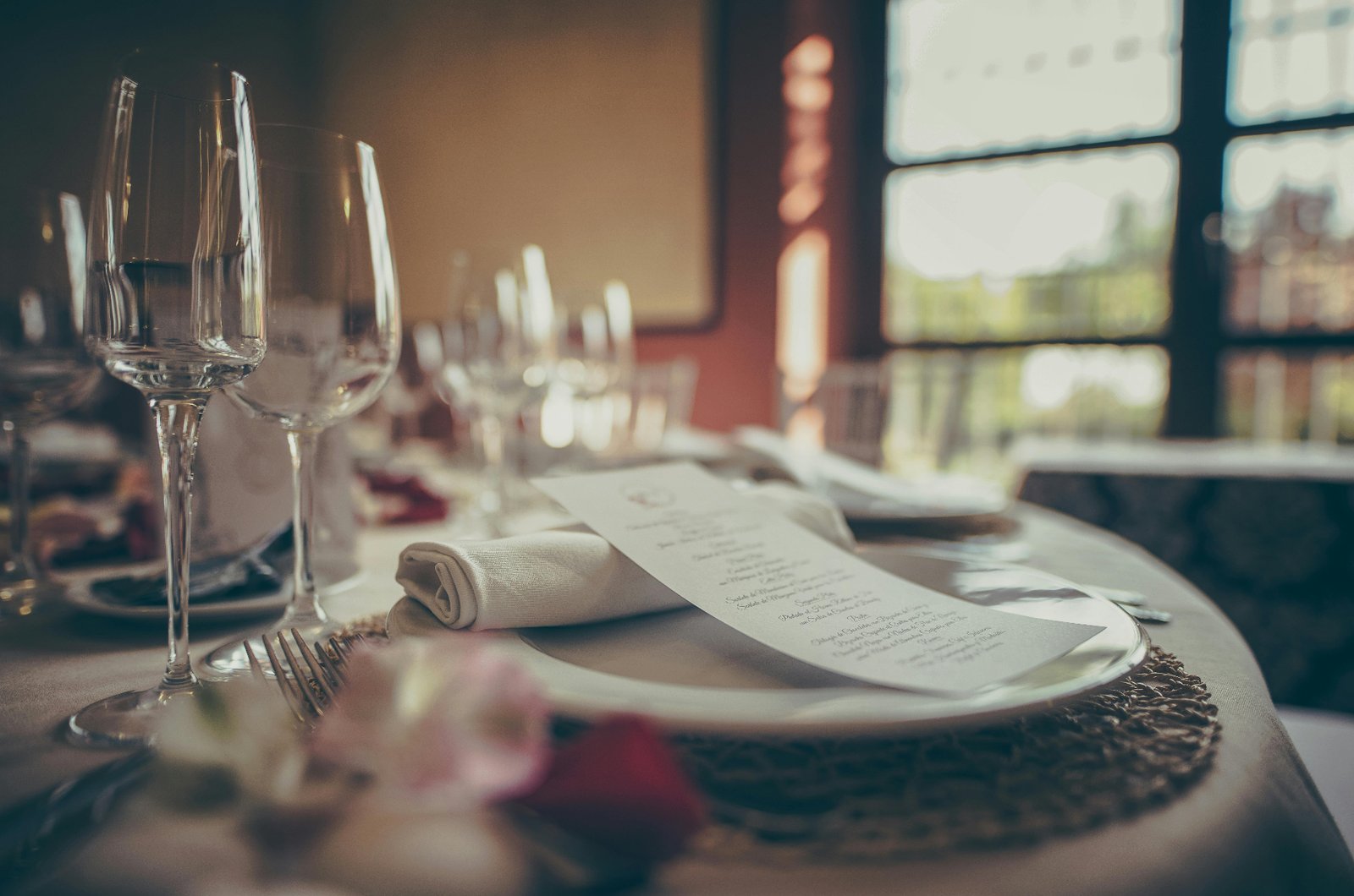 An elegant restaurant table setting with menu, wine glasses, and folded napkin ready for guests
