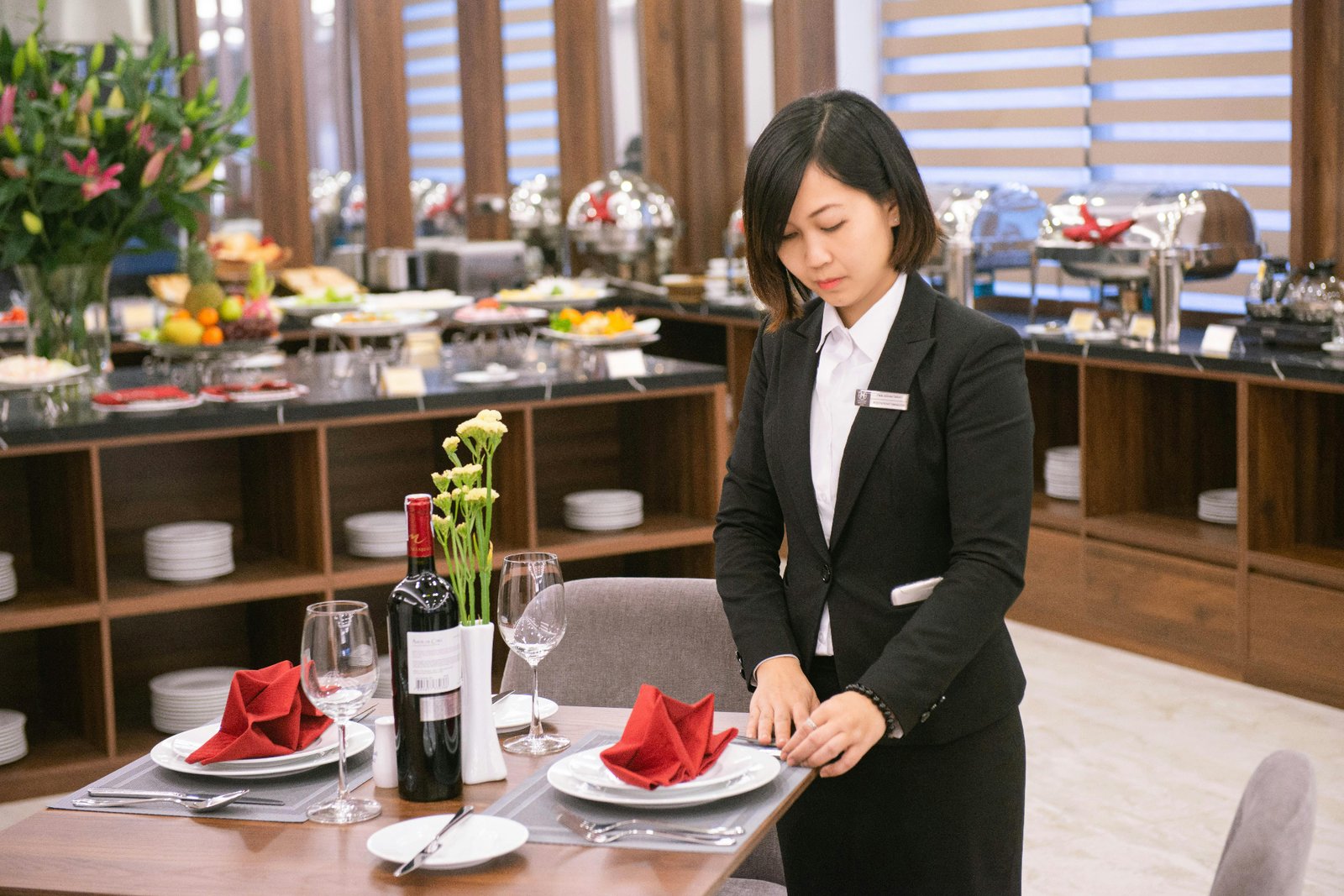 Restaurant manager preparing a private dining table with red napkins