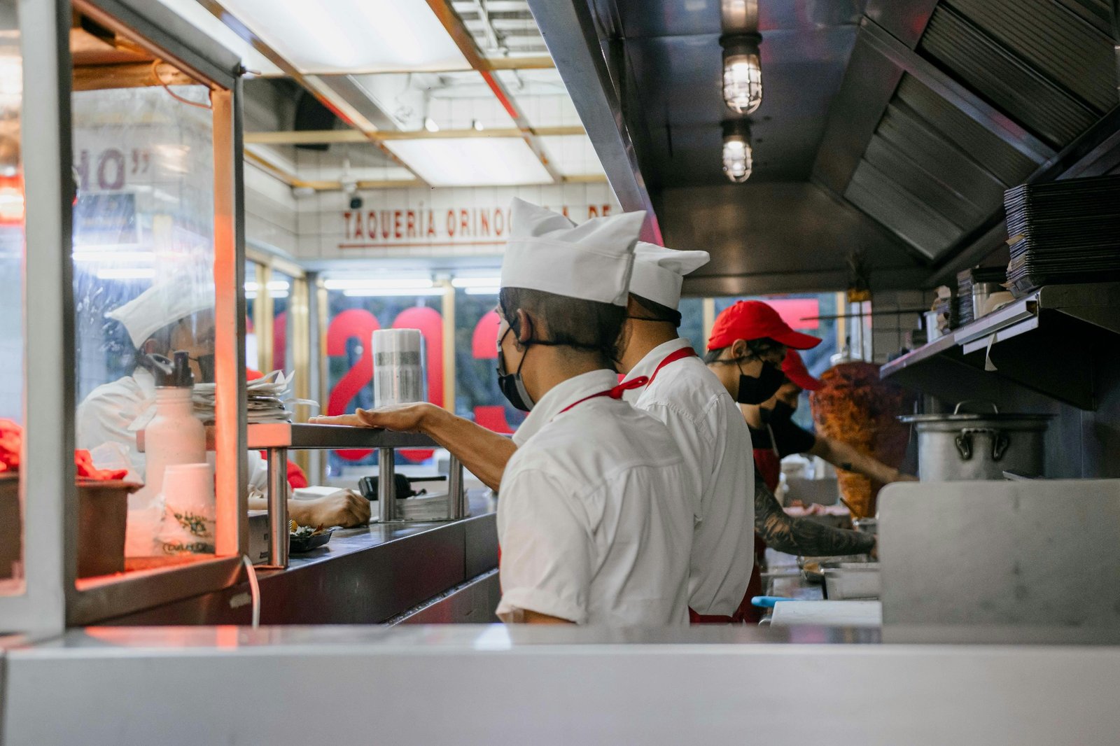 Busy taqueria kitchen staff working through orders during a rush